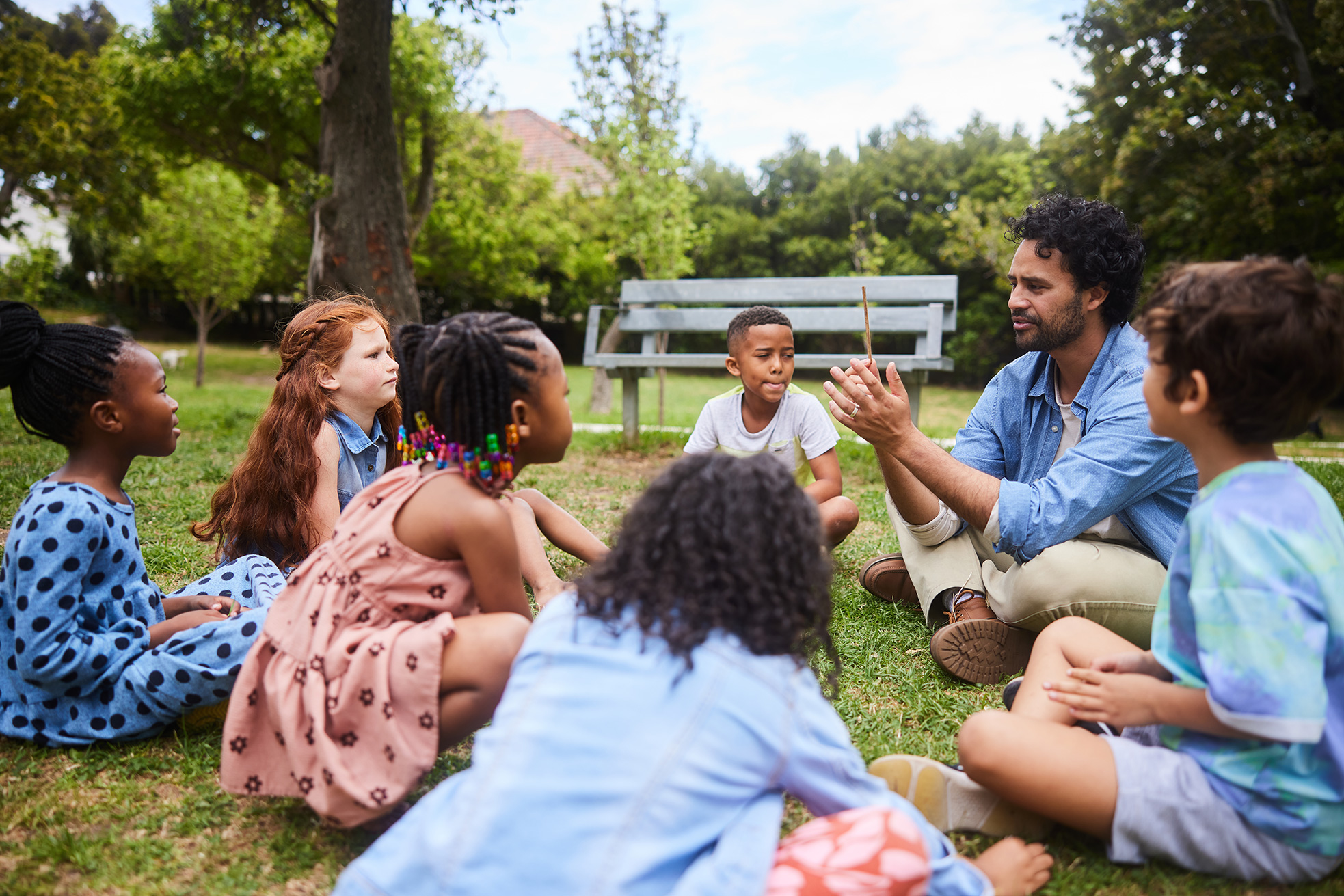 Teacher instructing children who are sitting in a circle